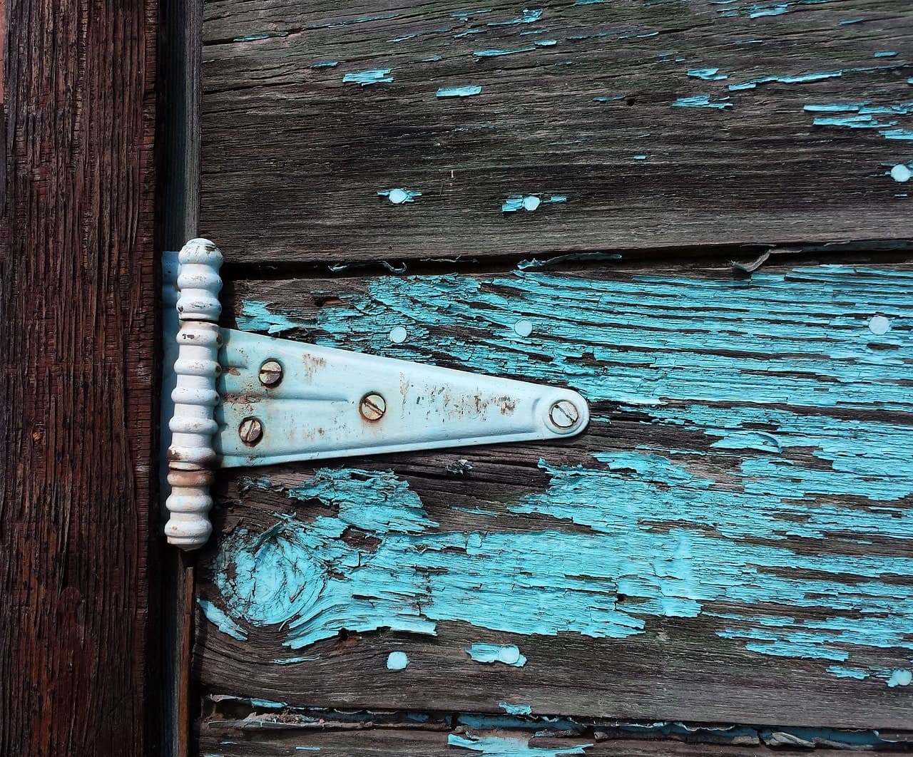 Door hinge being adjusted with a screwdriver